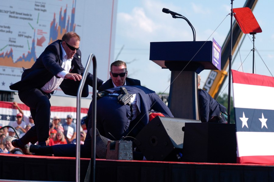 U.S. Secret Service agents converge to cover Republican presidential candidate former President Donald Trump at a campaign rally, Saturday, July 13, 2024, in Butler, Pa. (AP Photo/Evan Vucci) Republican presidential candidate former President Donald Trump is helped off the stage at a campaign event in Butler, Pa., Saturday, July 13, 2024. (AP Photo/Gene J. Puskar) Republican presidential candidate former President Donald Trump is helped off the stage at a campaign event in Butler, Pa., Saturday, July 13, 2024. (AP Photo/Gene J. Puskar) Republican presidential candidate former President Donald Trump is helped off the stage at a campaign event in Butler, Pa., on Saturday, July 13, 2024. (AP Photo/Gene J. Puskar) Republican presidential candidate former President Donald Trump is covered by U.S. Secret Service agents at a campaign rally, Saturday, July 13, 2024, in Butler, Pa. (AP Photo/Evan Vucci) Republican presidential candidate former President Donald Trump is surrounded by U.S. Secret Service agents at a campaign rally, Saturday, July 13, 2024, in Butler, Pa. (AP Photo/Evan Vucci) Republican presidential candidate former President Donald Trump is surrounded by U.S. Secret Service agents at a campaign rally, Saturday, July 13, 2024, in Butler, Pa. (AP Photo/Evan Vucci) Republican presidential candidate former President Donald Trump is helped off the stage at a campaign event in Butler, Pa., on Saturday, July 13, 2024. (AP Photo/Gene J. Puskar) Republican presidential candidate former President Donald Trump is helped off the stage at a campaign event in Butler, Pa., on Saturday, July 13, 2024. (AP Photo/Gene J. Puskar) Republican presidential candidate former President Donald Trump is surrounded by U.S. Secret Service agents at a campaign rally, Saturday, July 13, 2024, in Butler, Pa. (AP Photo/Evan Vucci)